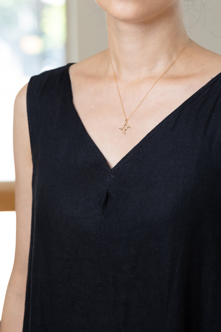 An Gemini necklace that shines at the neckline of a black dress.