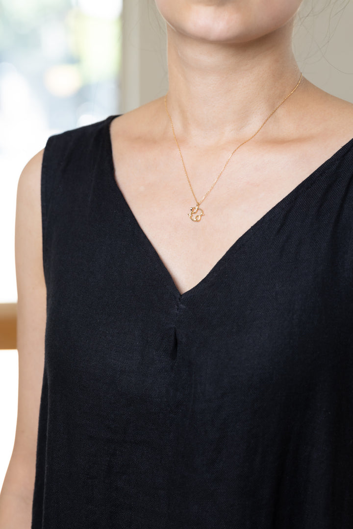 An Cancer necklace that shines at the neckline of a black dress.