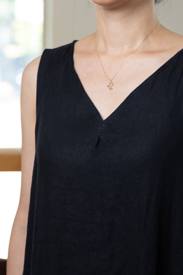 茶色の洋服に合わせたゴールドのしし座ネックレス