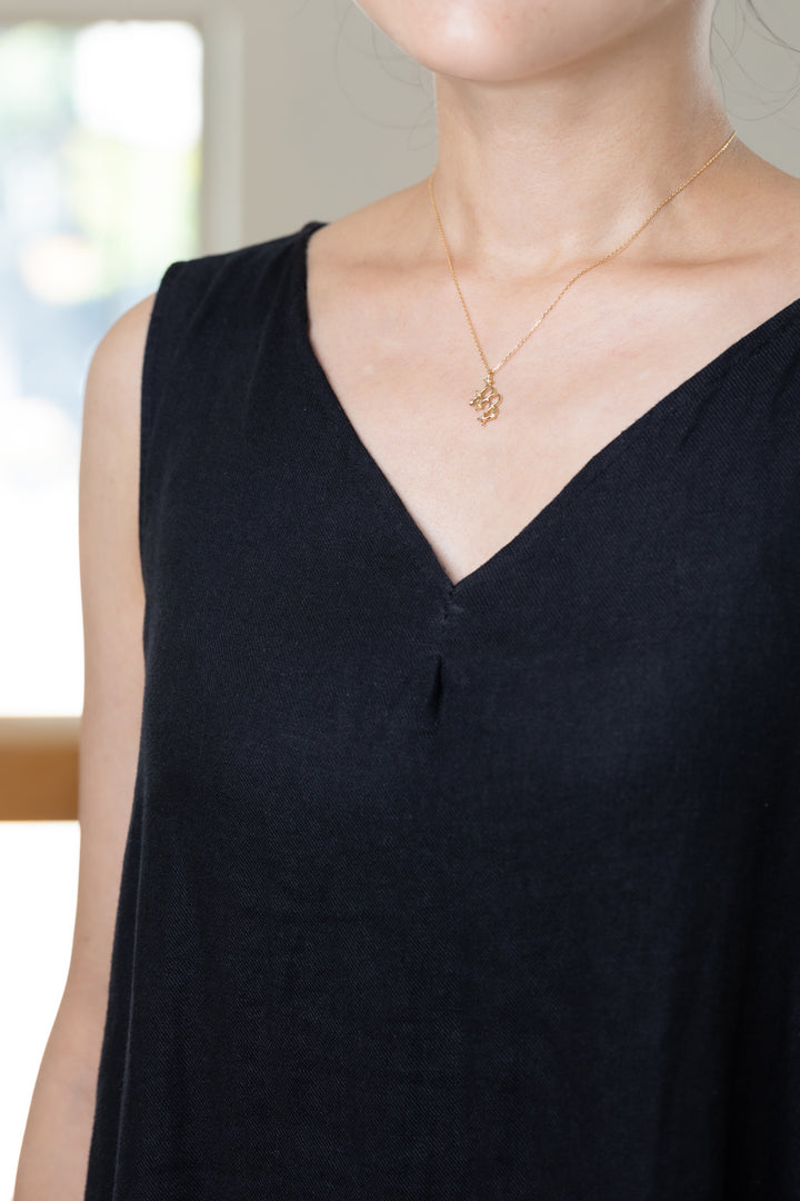 An Virgo necklace that shines at the neckline of a black dress.
