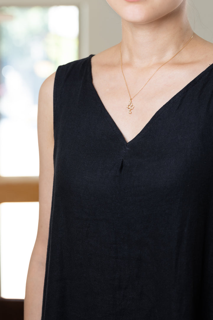 An Scorpio necklace that shines at the neckline of a black dress.