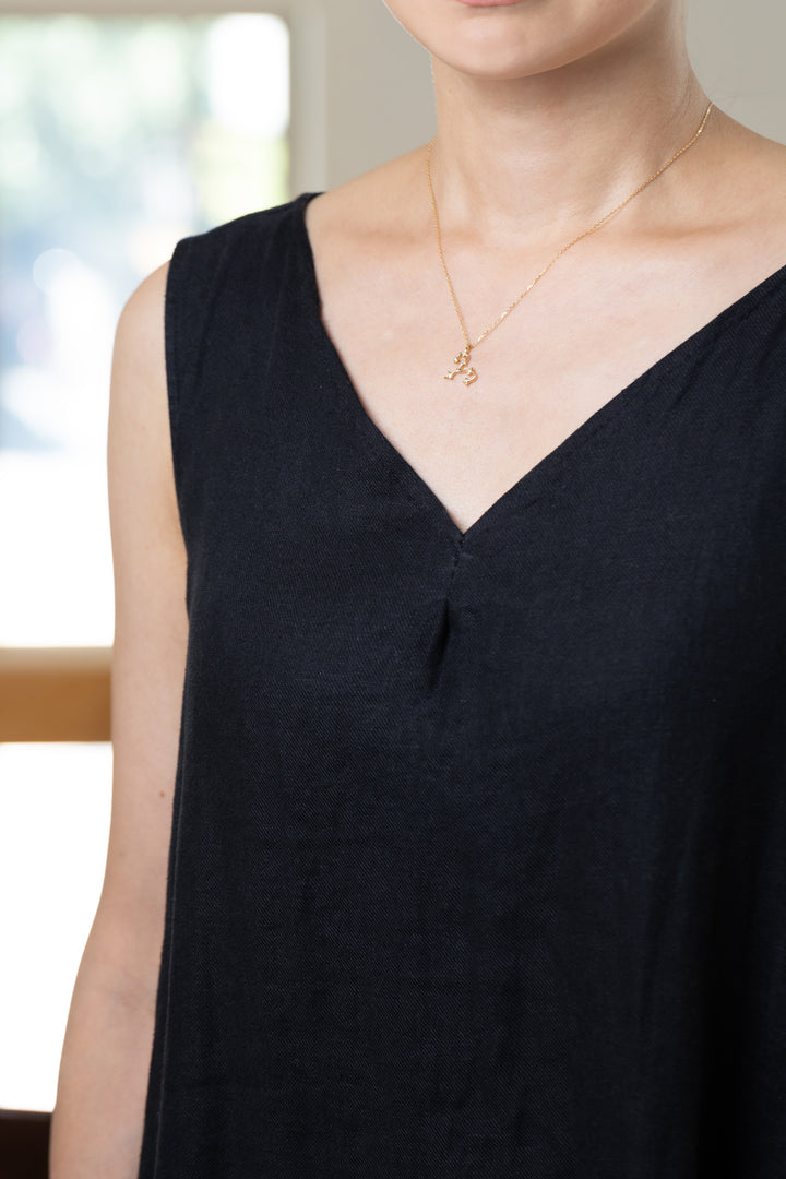 An Aries necklace that shines at the neckline of a black dress.