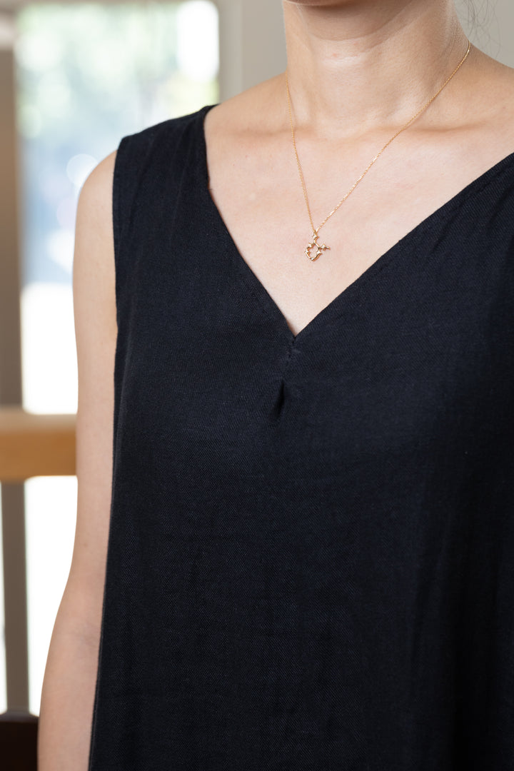 An Taurus necklace that shines at the neckline of a black dress.